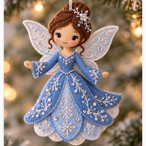 May include: A felt fairy ornament featuring brown hair styled in an updo with a snowflake hair accessory. The figure wears a blue dress adorned with white embroidered snowflake patterns, silver sequins, and small white beads on the wings and skirt.