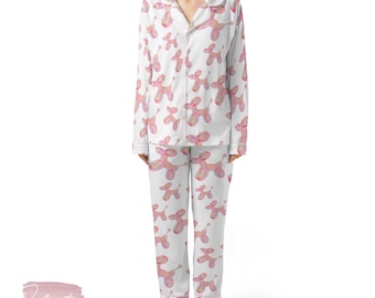 May include: White pyjama set featuring a pink balloon dog design. The long-sleeved top has a collared neckline and button-down front. The trousers are long and straight-legged. The trim and accents are pink.