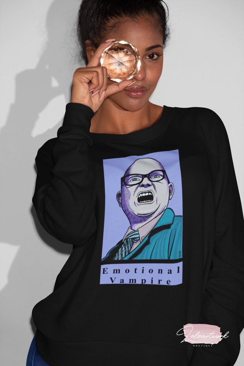 May include: Black sweatshirt with a graphic print of a man with glasses yelling. The text "Emotional Vampire" is printed below the graphic.