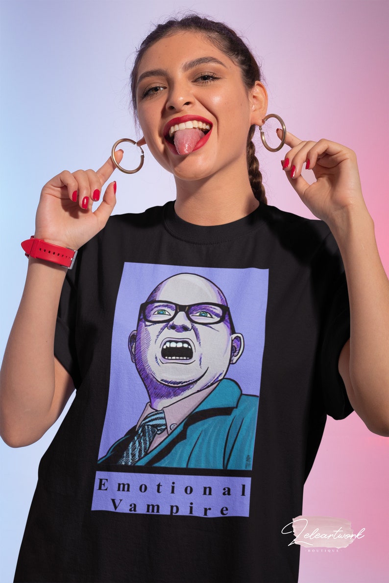 May include: Black t-shirt with a graphic print of a cartoon man with a surprised expression. The text "Emotional Vampire" is printed below the image.