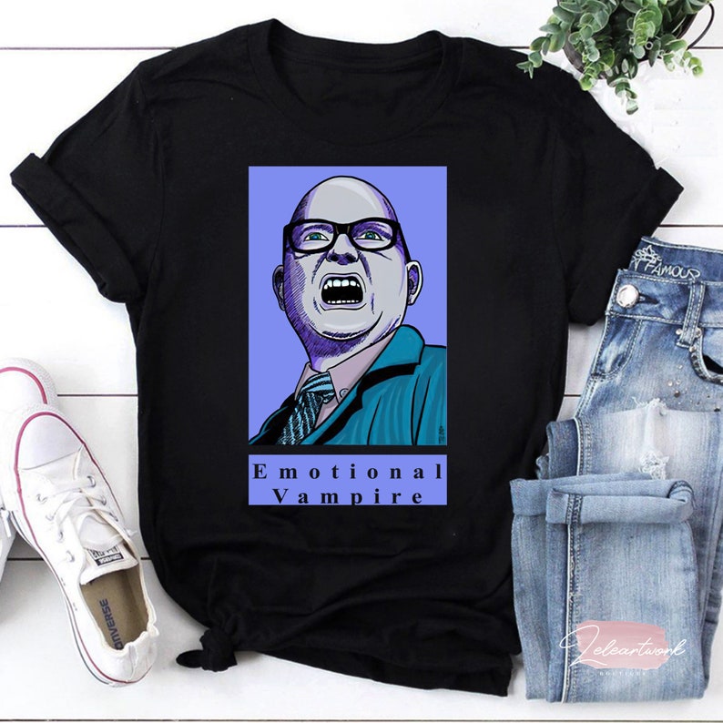 May include: Black t-shirt with a cartoon illustration of a man with glasses and the text "Emotional Vampire".