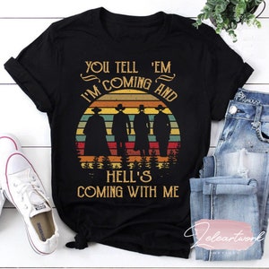 May include: Black t-shirt with a vintage sunset graphic and the text "You tell 'em I'm coming and hell's coming with me".