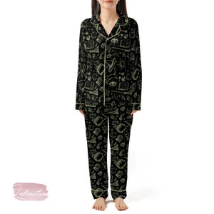 Può includere: Pigiama nero con un motivo ripetuto di simboli stregoneschi in verde chiaro. Il set include una camicia abbottonata con finiture bianche e pantaloni abbinati. Il design presenta libri, lune, stelle e calderoni.