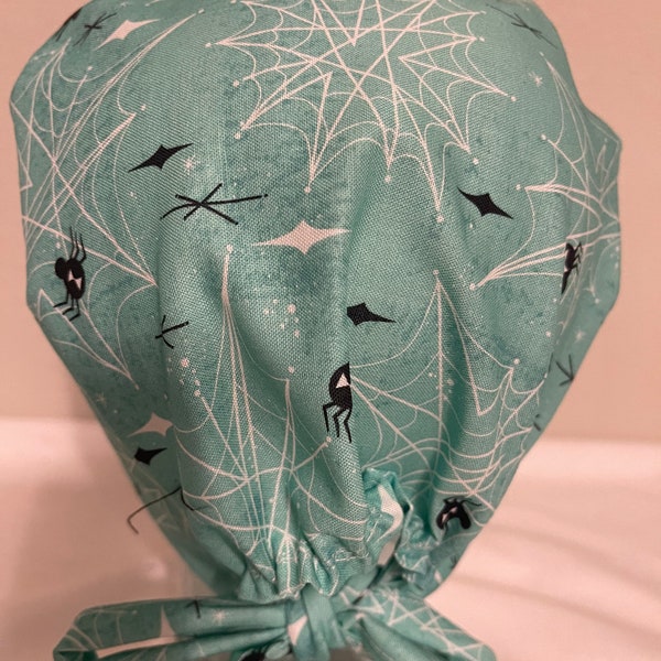 Woman’s teal Halloween spider web pixi/euro style surgical scrub hat