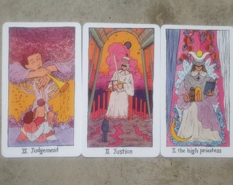 May include: Three tarot cards with colorful illustrations. The first card is Judgement, depicting an angel blowing a trumpet. The second card is Justice, showing a figure holding a sword and scales. The third card is the High Priestess, featuring a figure wearing a crown and holding a book.