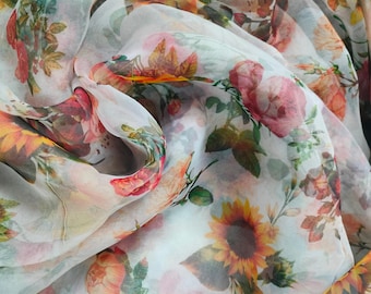 Puede incluir: Tela blanca transparente con estampado floral de rosas, girasoles y hojas. La tela es translúcida y tiene una textura delicada.