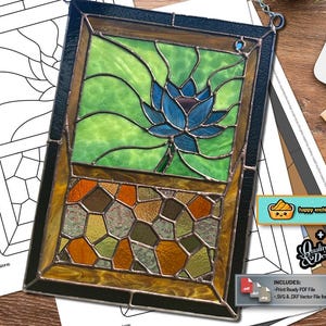 Könnte beinhalten: Buntglasfenster mit einer blauen Lotusblume und grünen Blättern im oberen Bereich und einem abstrakten Mosaikdesign unten. Der Rahmen ist schwarz und goldfarben. Enthält PDF- und SVG-Dateien.