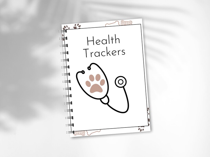 May include: A white spiral bound notebook with a brown paw print and stethoscope design. The cover reads "Health Trackers".