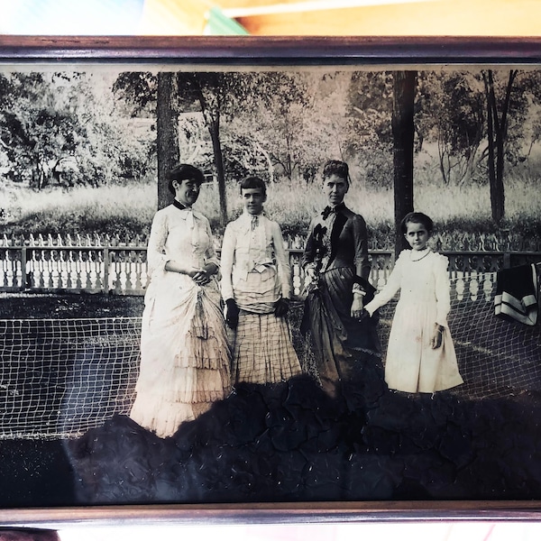 Glass positive 1870s image of women playing lawn tennis framed as a window hanging