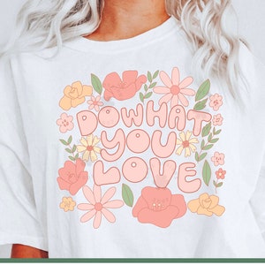 May include: A white t-shirt with a floral design and the text "Do what you love" in pink and yellow letters.