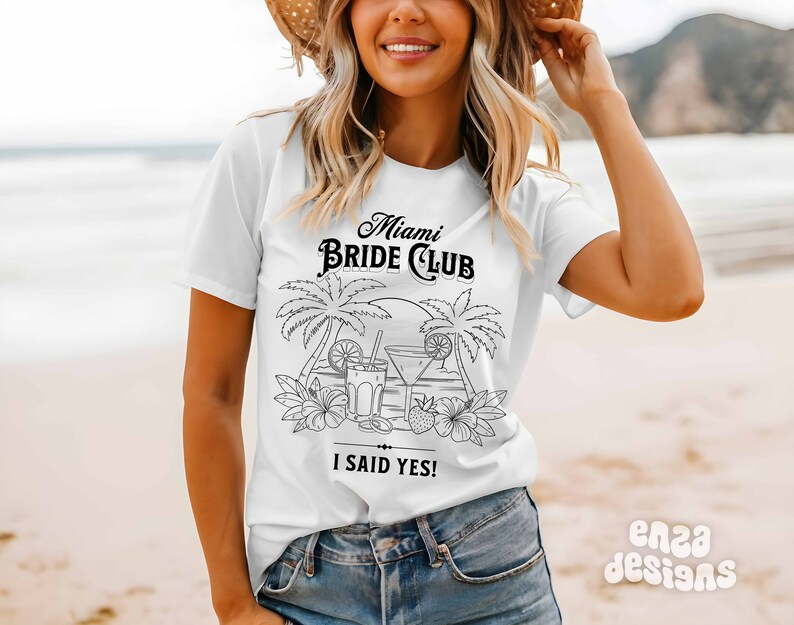 May include: White t-shirt with a black graphic design that says "Miami Bride Club" with palm trees and cocktails. The text "I said yes!" is below the graphic.