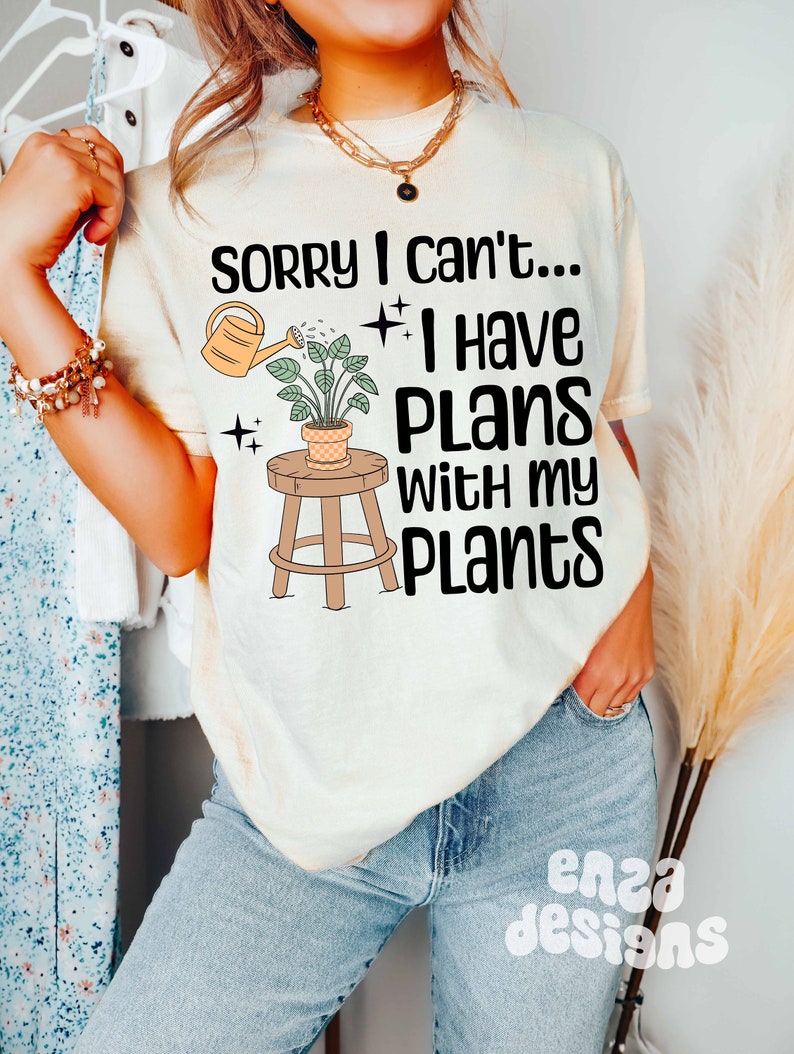 May include: A white t-shirt with the text "Sorry I can't... I have plans with my plants" and a graphic of a potted plant with a watering can.