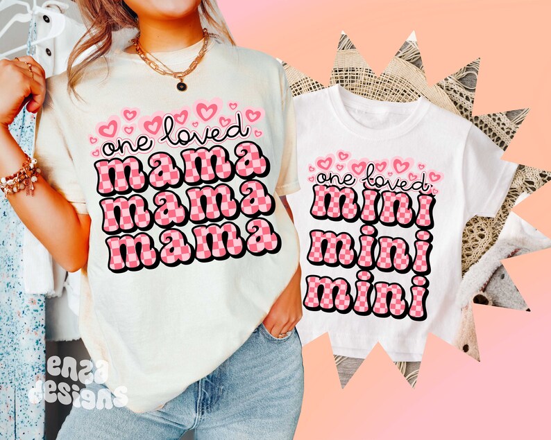 May include: Two white t-shirts with pink checkered text. The larger shirt says "one loved mama mama mama" and the smaller shirt says "one loved mini mini mini".