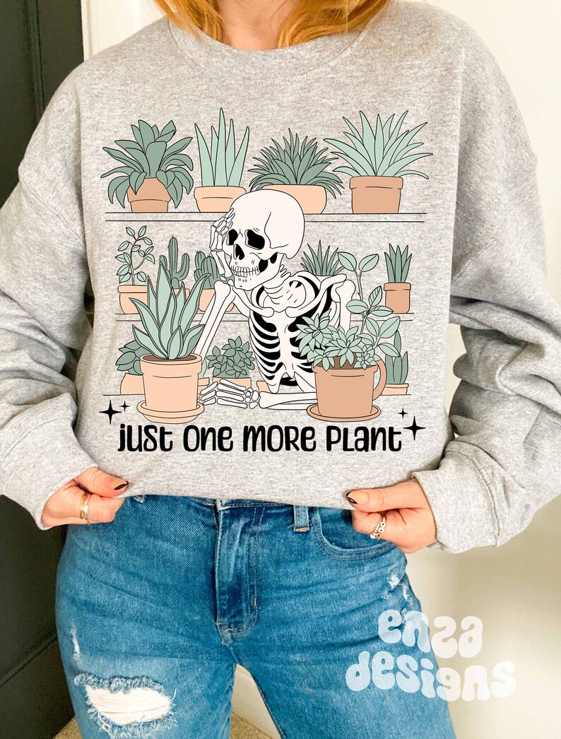 May include: A gray sweatshirt with a skeleton surrounded by potted plants. The text "just one more plant" is printed below the skeleton.