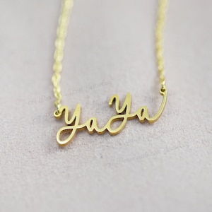 May include: A gold necklace with the word "yaya" written in cursive script.