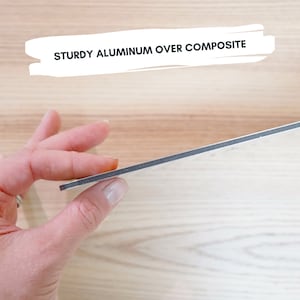 K&ouml;nnte beinhalten: Nahaufnahme eines Verbundmaterials mit einer robusten Aluminium-Oberschicht. Der Text "STURDY ALUMINUM OVER COMPOSITE" wird in einem wei&szlig;en Banner angezeigt. Das Material wird von einer Hand gehalten, die seine Kante und Dicke zeigt.
