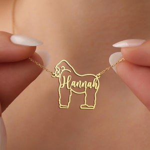 May include: Gold necklace with a gorilla silhouette pendant and the name "Hannah" inscribed on it.