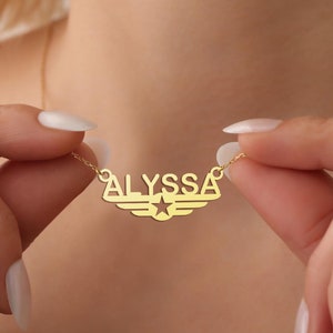 Puede incluir: Collar de oro con un dise&ntilde;o de estrella y alas. El nombre "ALYSSA" est&aacute; escrito en el collar.