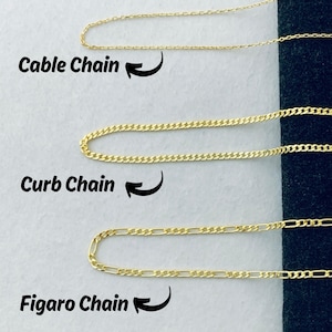 Peut inclure: Pr&eacute;sentation de trois types de cha&icirc;nes en or : c&acirc;ble, gourmette et figaro. Chaque cha&icirc;ne est montr&eacute;e avec une section incurv&eacute;e et son nom est indiqu&eacute;. Les cha&icirc;nes sont pos&eacute;es sur un fond bleu fonc&eacute;, mettant en valeur leur couleur dor&eacute;e.