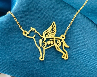 May include: Gold necklace with a pendant shaped like a dog with wings. The dog's name, "Boo", is spelled out within the outline of the pendant.