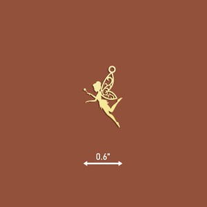 May include: Gold-colored metal charm featuring a fairy silhouette with wings and a wand. The charm is 0.6 inches in size.