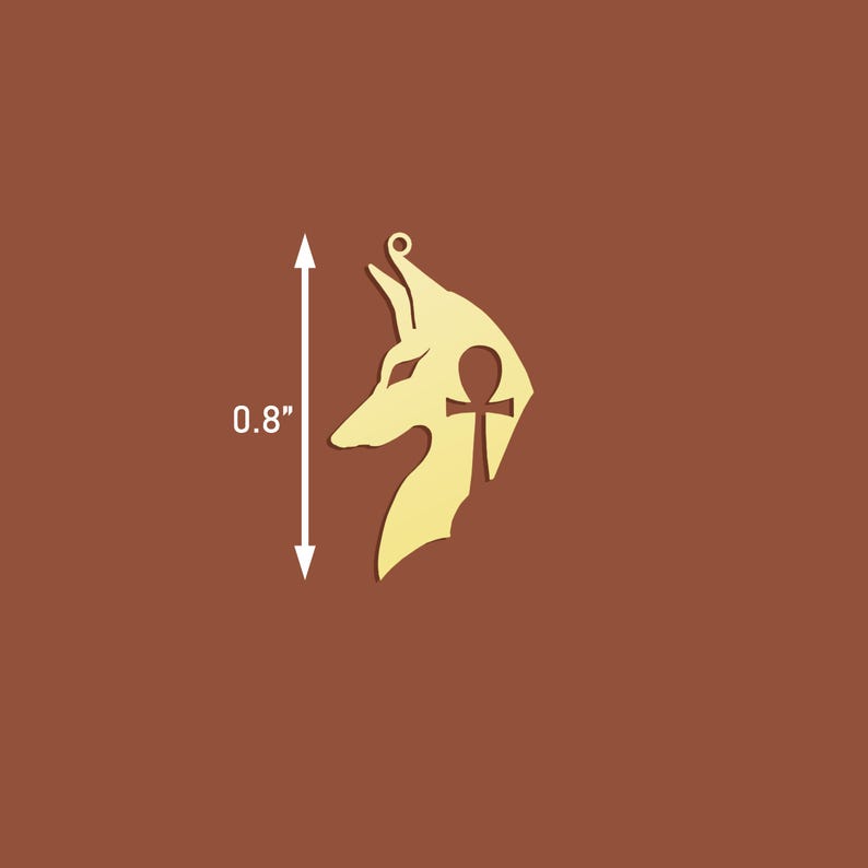 Op de afbeelding: Gouden metalen hanger met een silhouet van een Anubis-jakhalskop met een ankh-symbool erin. De hanger is 0,8 inch hoog.