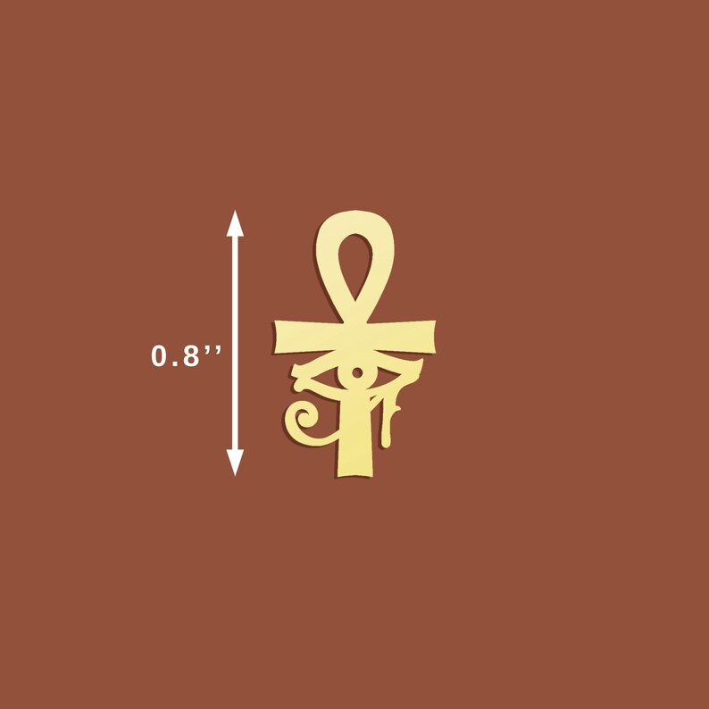 Peut inclure: Un pendentif ankh dor&eacute;, mesurant 2 cm de hauteur, sur fond marron. L'ankh, symbole &eacute;gyptien antique de la vie, pr&eacute;sente une boucle en haut, une barre horizontale et un motif d'&oelig;il stylis&eacute;.