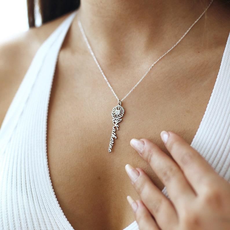 May include: A silver necklace with a delicate flower pendant and the name "Katherine" spelled out in cursive.