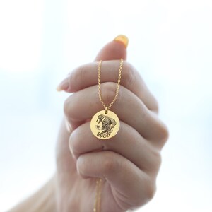 May include: A gold pendant necklace with a detailed engraved image of a dog's face. The dog's name, "Ryder," is inscribed below the image. The pendant hangs from a fine gold chain.