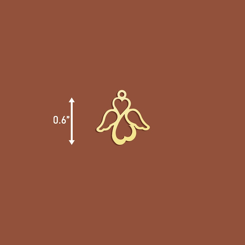 May include: Gold metal angel charm with wings and a heart design. The charm is 0.6 inches tall.