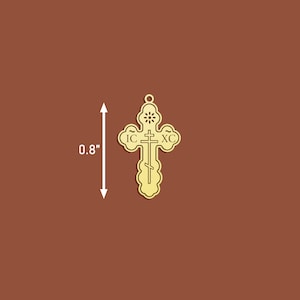 May include: A gold-coloured metal cross pendant with intricate details. The cross features the inscription "IC XC" and a small circle at the top. The pendant measures 0.8 inches in height.