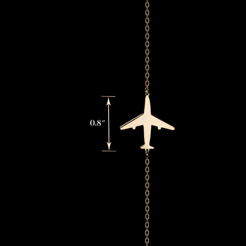 Op de afbeelding: Gouden vliegtuigbedelketting met een delicate ketting. De vliegtuigbedel is 0,8 inch breed.