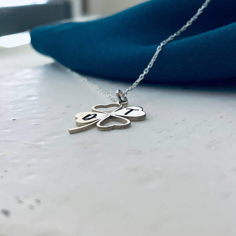 Peut inclure: Un collier en argent avec un pendentif en forme de tr&egrave;fle &agrave; quatre feuilles. Le pendentif porte les lettres "B" et "T" grav&eacute;es.