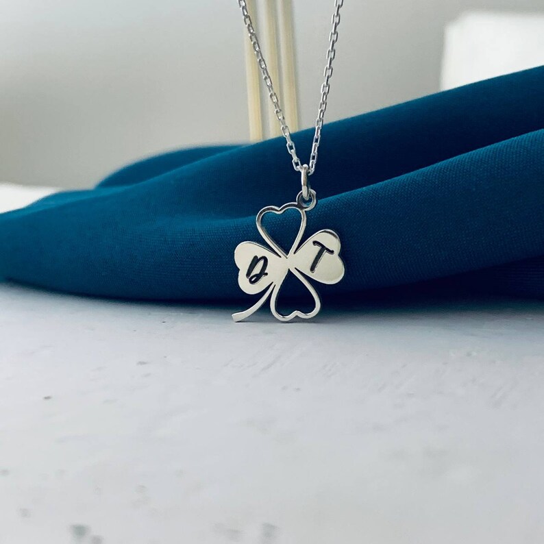Peut inclure: Un collier en argent avec un pendentif en forme de tr&egrave;fle &agrave; quatre feuilles. Le pendentif porte les lettres "B" et "T" grav&eacute;es.