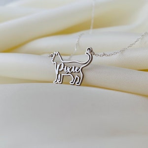May include: Silver cat necklace with the name "Pixie" cut out inside the silhouette.