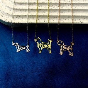 May include: Three gold necklaces with dog silhouettes and names. The necklaces are on a white textured surface. The names are "Dax", "Macy", and "Charlie".