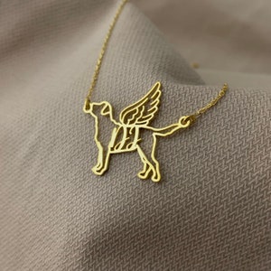 Puede incluir: Collar de oro con un recorte detallado de un perro con alas. El perro est&aacute; mirando hacia adelante con la cabeza inclinada hacia arriba. Las alas est&aacute;n extendidas detr&aacute;s del perro.