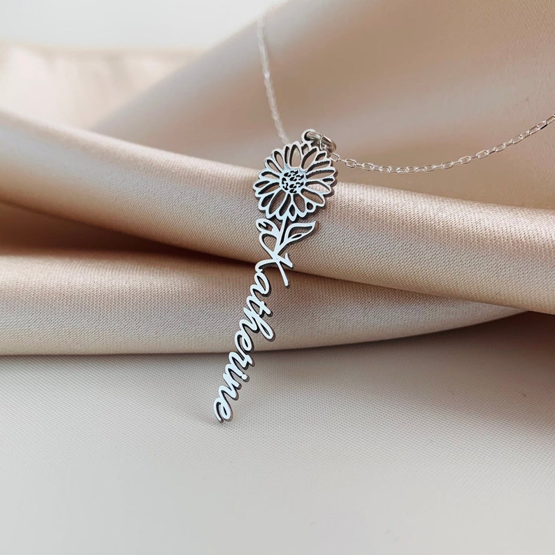 May include: Silver necklace with a delicate sunflower charm and the name "Katherine" written in cursive.