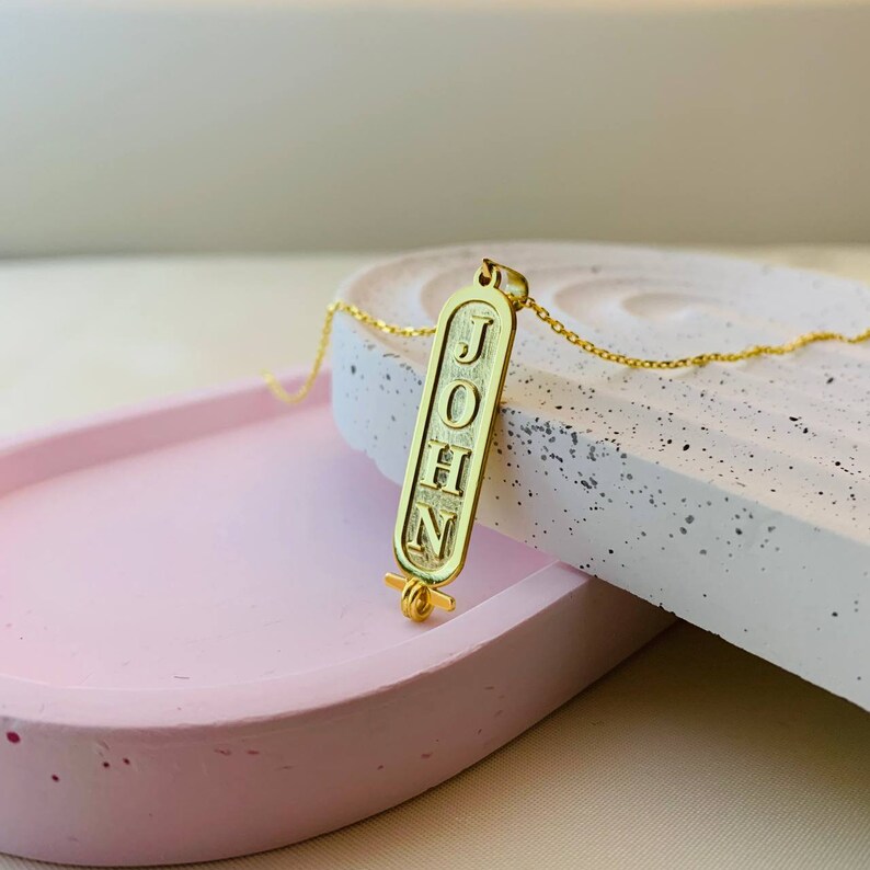 K&ouml;nnte beinhalten: Goldkette mit einem Anh&auml;nger in Form eines &auml;gyptischen Hieroglyphen. Der Anh&auml;nger tr&auml;gt den Namen "JOHN" eingraviert.