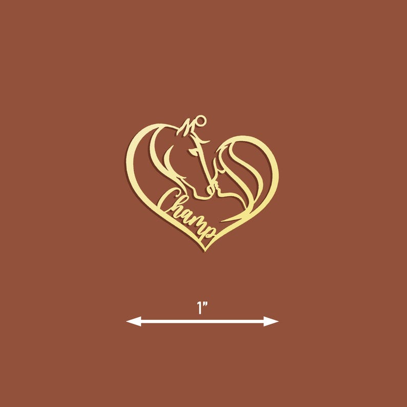 May include: Gold-colored wooden heart-shaped ornament with a silhouette of two horses' heads inside the heart. The word "Champ" is written inside the heart.