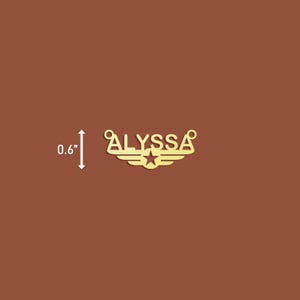 Puede incluir: Encanto de metal dorado con el nombre "ALYSSA" en may&uacute;sculas, con una estrella y alas a cada lado. El encanto tiene 0,6 pulgadas de alto.