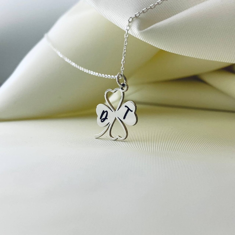 Peut inclure: Collier en argent avec un pendentif en forme de tr&egrave;fle &agrave; quatre feuilles. Le pendentif est grav&eacute; des lettres "D" et "T".