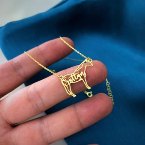 Peut inclure: Un collier en or avec un pendentif en forme de cheval. Le cheval est en m&eacute;tal et le nom "Sittin" est &eacute;pell&eacute; dans le corps du cheval.
