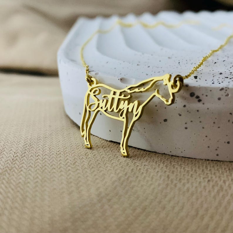Peut inclure: Collier en or en forme de cheval avec le nom "Suttyn" d&eacute;coup&eacute; dans le corps du cheval.