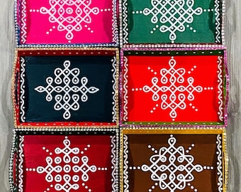 May include: Eight decorative wooden trays with colorful backgrounds and white geometric designs. The trays are arranged in two rows of four. The trays are all different colors, including red, blue, green, brown, and pink.