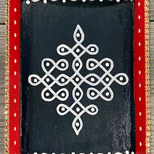 May include: A red wooden tray with a gold trim and a white geometric design on a black background.