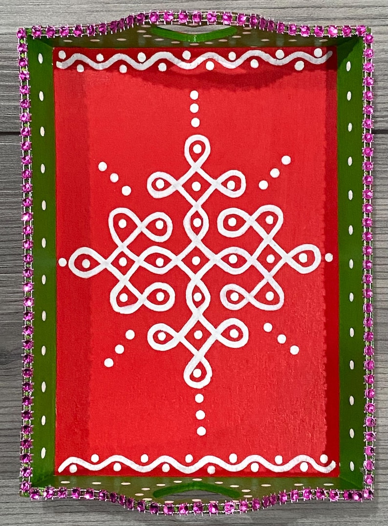 May include: A green and red tray with a white geometric design. The tray is decorated with a pink rhinestone border.