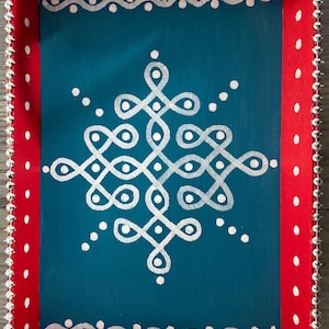 May include: A teal wooden tray with a white geometric design painted on the surface. The tray has a red border with white polka dots and a silver beaded trim.