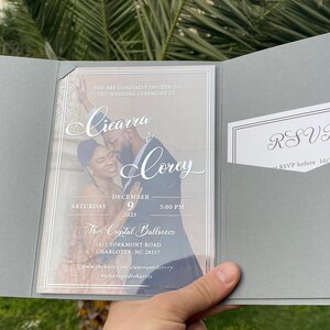 May include: A wedding invitation with a photo of the couple, Ciearra and Corey, on a clear background. The invitation is for a wedding ceremony on December 9th, 2023 at 5:00 PM at The Crystal Ballroom, 2421 Yorkmont Road, Charlotte, NC 28217. The RSVP deadline is 10/5/2023.
