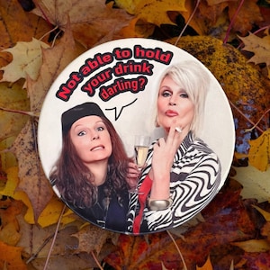 Könnte beinhalten: Ein runder Knopf mit weißem Hintergrund und einem Schwarzweißbild von zwei Frauen. Der Text auf dem Knopf lautet "Not able to hold your drink darling?"